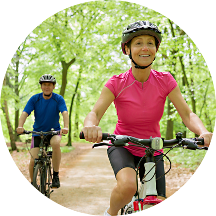 A couple biking through woods.
