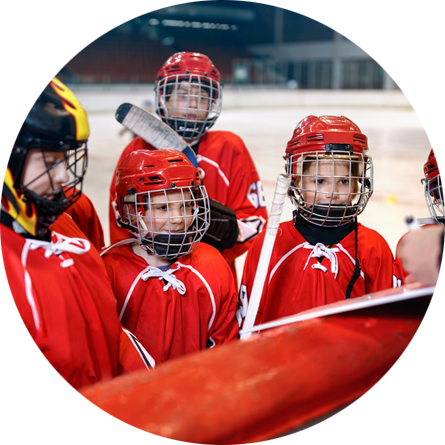 A kids in hockey gear listening to coach off-frame