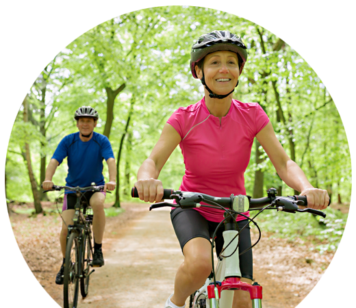 A couple biking through woods.